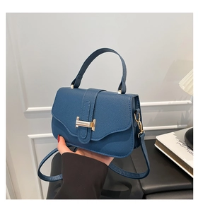 Detailed macro of blue litchi grain PU leather bag with golden H-shaped metal buckle
