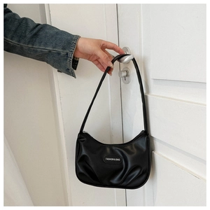Dettaglio della borsa a mezzaluna nera con design a pieghe e placchetta logo di moda