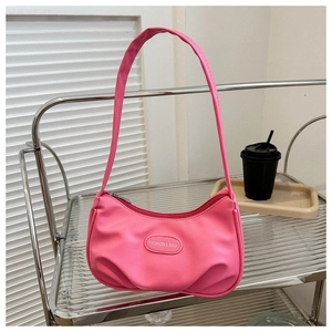 Dettaglio della borsa sottospalla rosa acceso a mezzaluna con fondo a pieghe