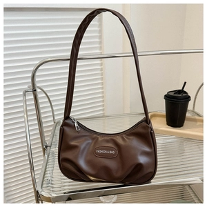 Dettaglio della borsa a mezzaluna in pelle PU marrone scuro con texture a pieghe su rack