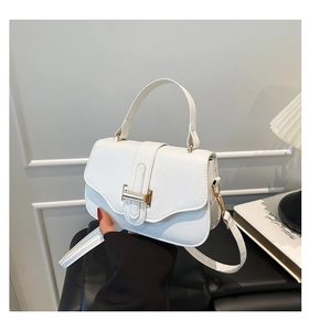 Detail of white lychee texture handbag with elegant gold metal buckle and top handle