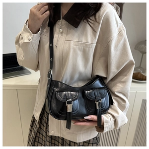 Detail of vintage black oil wax leather crossbody bag with dual silver buckle pockets