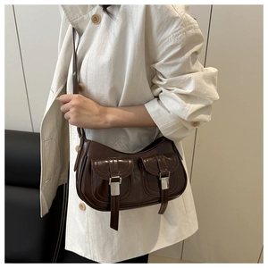Polished faux leather tote bag with silver buckle pockets shown on cream coat