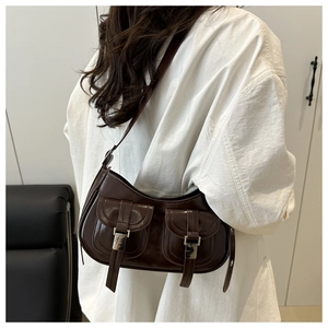 Detail of vintage oil wax leather shoulder bag with glossy finish and front buckle pockets