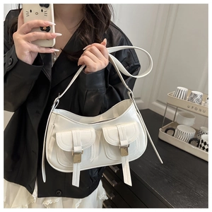Detail view of a white vintage oil-wax leather shoulder bag with silver buckle pockets
