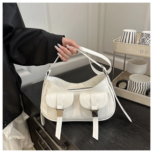 Close-up of white semi-circle handbag with two front pockets and silver buckle detail