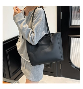 Fashionable black leather tote bag shown on a female model for commuting and style