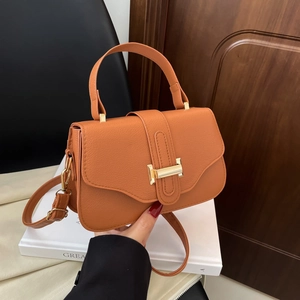 Chic orange litchi leather crossbody bag with top handle and gold metal clasp