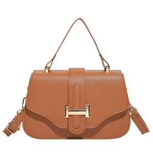Brown lychee leather vintage crossbody bag with gold buckle and top handle in studio view