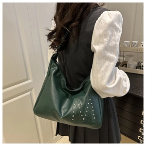Detail of green hobo bag featuring silver studs forming an M logo on matte leather