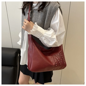 Details der dunkelroten Hobo-Tasche mit silbernem Niet-M-Logo auf weichem Lederfinish