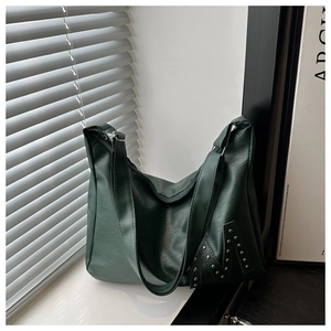 Detailed view of silver rivets forming an M shape on green lychee leather tote bag