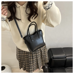 Minimalistische schwarze Leder-Eimertasche als Umhängetasche an einem Model gezeigt