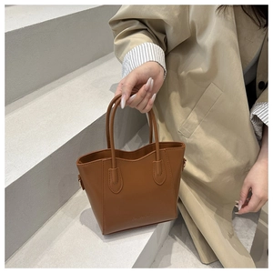 Close-up of premium brown leather bucket bag with FASHION lettering and stitching
