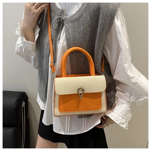 Detail showing orange leather and beige woven texture on crossbody bag with U-shaped buckle
