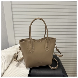 Detail of khaki bucket bag showing smooth PU texture and debossed FASHION text