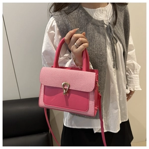 Detail of rose pink plaid crossbody bag with golden water-drop twist lock and hard handle