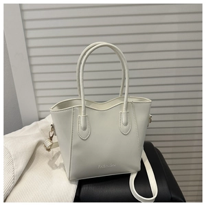 Detail view of white leather tote bag with FASHION engraving and detachable shoulder strap