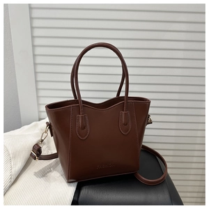Close-up of brown leather bucket bag featuring fashion embossing and adjustable strap