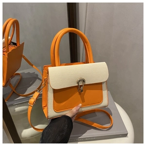 Détail du sac bandoulière chic orange et beige avec serrure dorée et rabat texturé