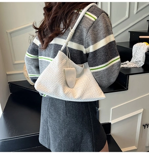 Detail view of white woven texture and seamless integrated strap on the oversized hobo bag