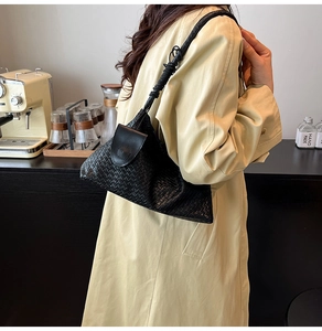 Close-up of black woven leather hobo shoulder bag with textured handle and slouchy design