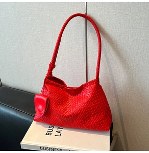 Close-up of bright red woven faux leather handbag with a matching round mini coin purse