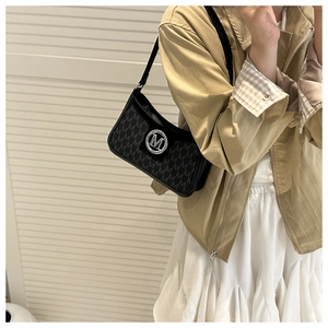 Detail of black underarm bag featuring jacquard M-texture and silver metallic M-logo