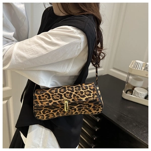 Detailansicht der Schultertasche mit Leopardenmuster und Goldschließe an einem Model