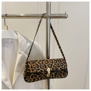 Detail der Schultertasche mit Leopardenmuster und Goldverschluss zum Streifenblazer