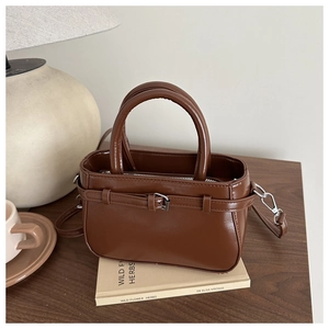 Détail du sac à main vintage en similicuir marron foncé avec boucle décorative