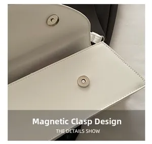 Macro detail of the magnetic clasp closure on a white minimalist crossbody handbag