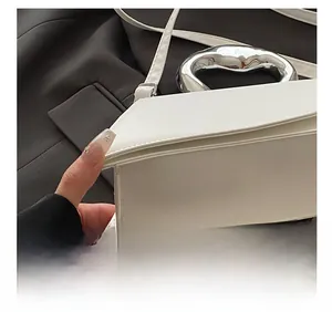 Detail of white leather handbag with unique silver metal ring handle and precise stitching