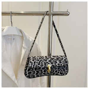 Detail der grauen Tasche mit Leopardenmuster, weicher Textur und goldenem Metallverschluss