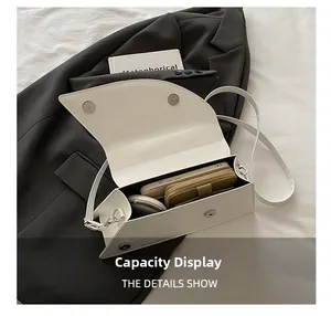 Capacity display of white minimalist shoulder bag showing phone and wallet storage