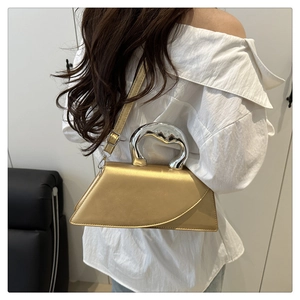 Detail of champagne gold handbag featuring a unique silver metallic irregular handle