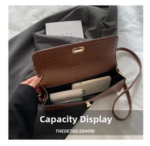 Détail de l'intérieur du sac carré tressé contenant un téléphone et un portefeuille