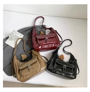 Three glossy faux leather tote bags in burgundy, khaki, and black with bear charms