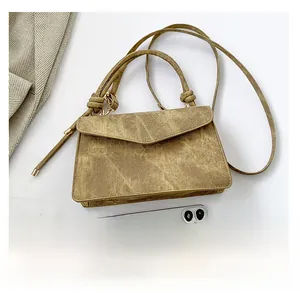 Retro brown textured crossbody bag shown with a smartphone for size reference comparison