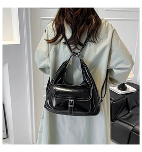Detailed view of black oil wax leather tote bag with white contrast stitching on model