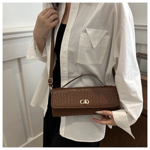Détail du sac à bandoulière en cuir tressé marron foncé avec fermoir doré tournant