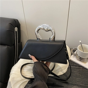 Modern black geometric crossbody bag with a distinctive liquid silver metal handle