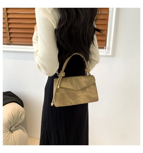 Detail view of khaki green textured square bag with distinctive knotted handle design