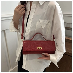 Détail du petit sac carré rouge tressé avec fermoir doré et bandoulière réglable