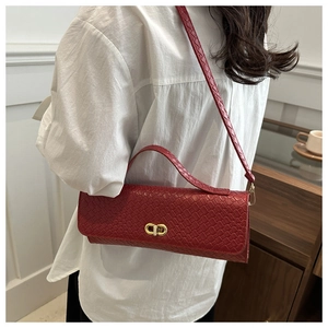 Détail du sac à main en cuir tressé rouge avec boucle dorée et bandoulière élégante