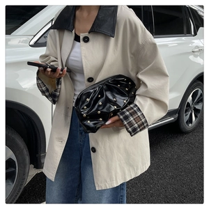 Detail of beige casual jacket featuring black leather collar and vintage plaid cuffs