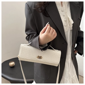 Détail du sac à bandoulière blanc à texture tissée avec boucle dorée à double anneau