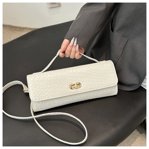 Détail d'un sac bandoulière blanc à texture tressée et fermoir rotatif doré élégant