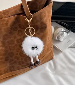 Detail eines kreativen Plüsch-Anhängers mit langen Beinen an einer Tasche