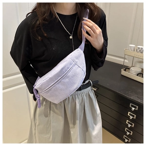 Detail of light purple corduroy belt bag with silver zipper and woven drawstring puller
